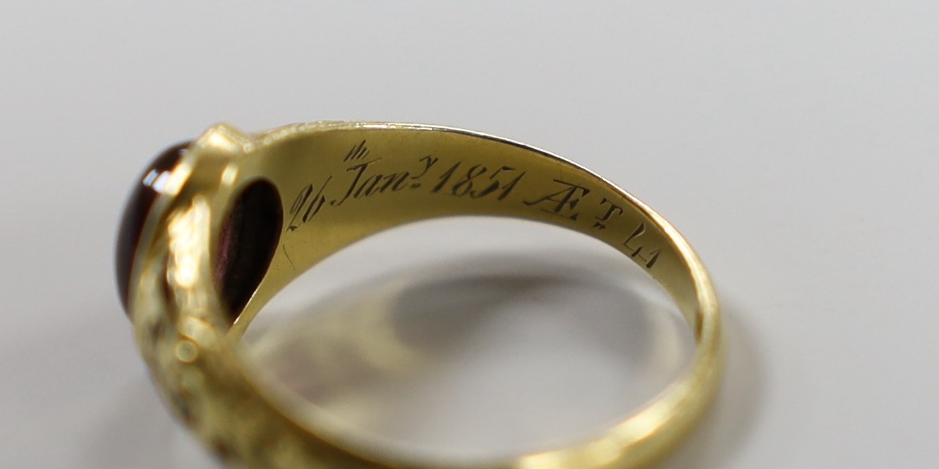 A Victorian 18ct gold, cabochon garnet and black enamel set memorial ring, the shank interior inscribed 'J W Scott obt. 26th Jan, 1851 at 41', size J, gross weight 2.8 grams.